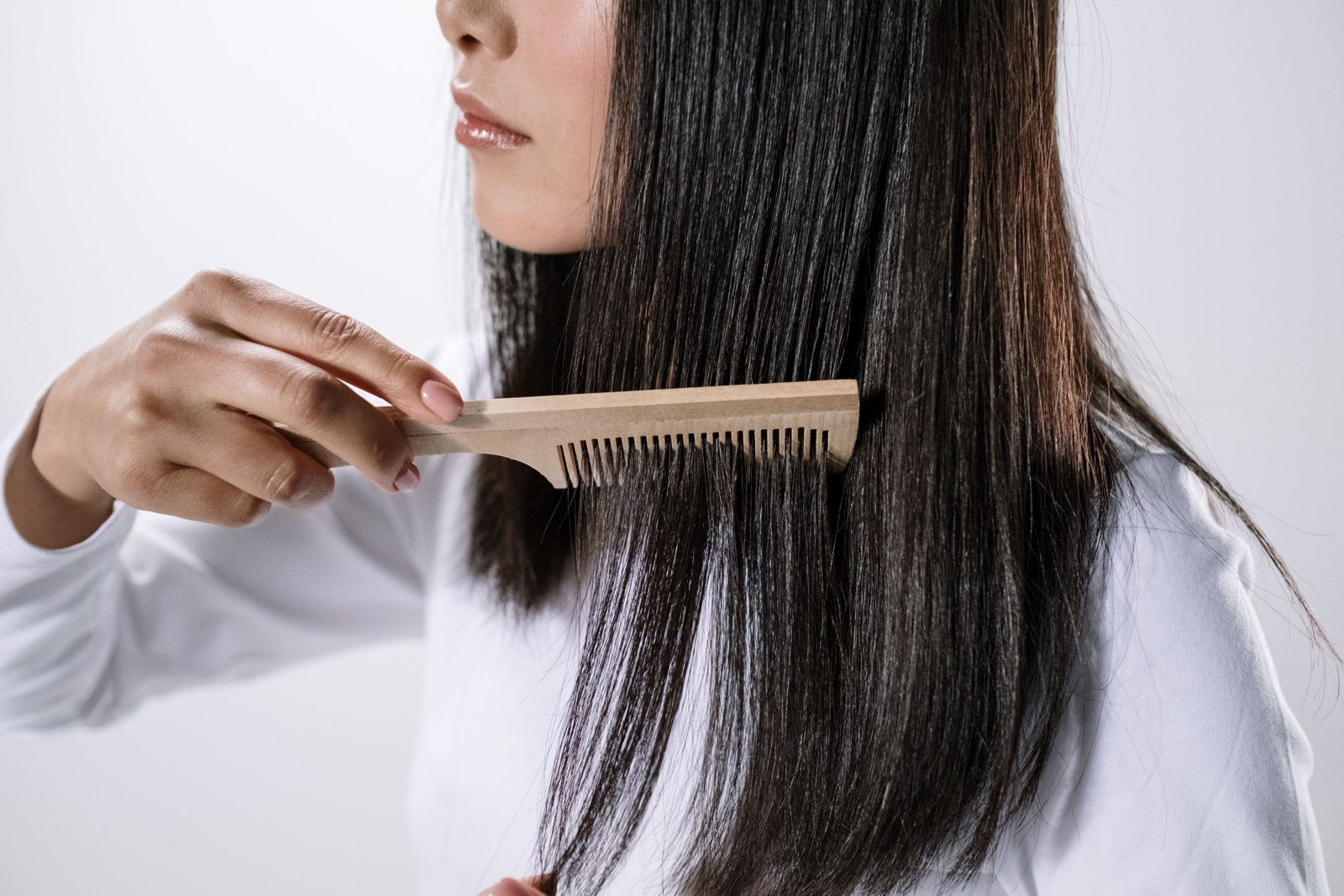 Une longue chevelure cuivrée peignée avec un peigne en bois